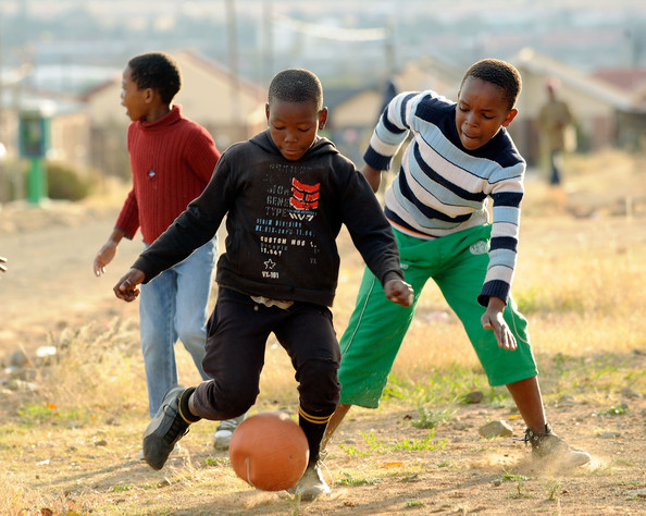 Children playing football on a dusty field in South Africa  *** image courtesy of zimbio ***